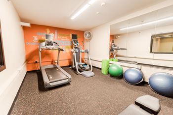 a gym with treadmills and weights on the floor